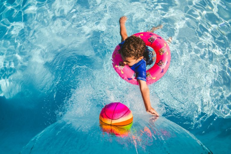 a child in a flaotatio device cases after a ball in water