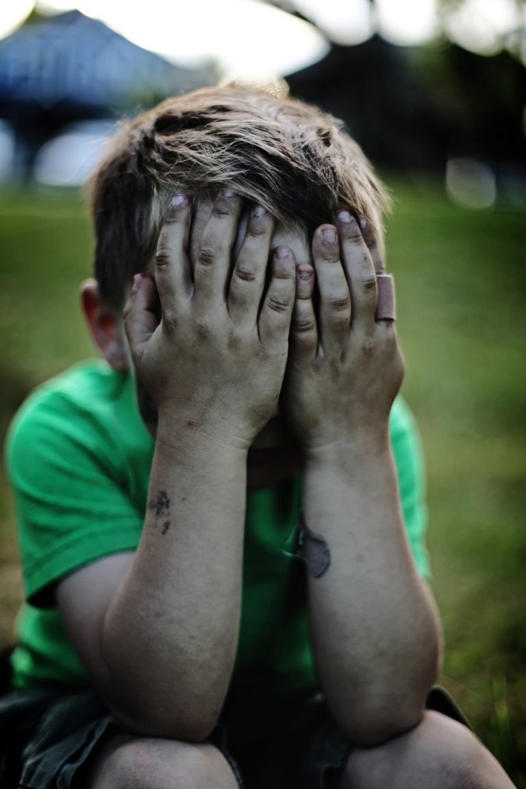 boy covers his face in anger or upset