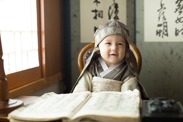 baby sits in front of a book