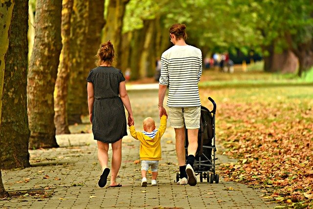 2 adults and a child walk down the sidewalk